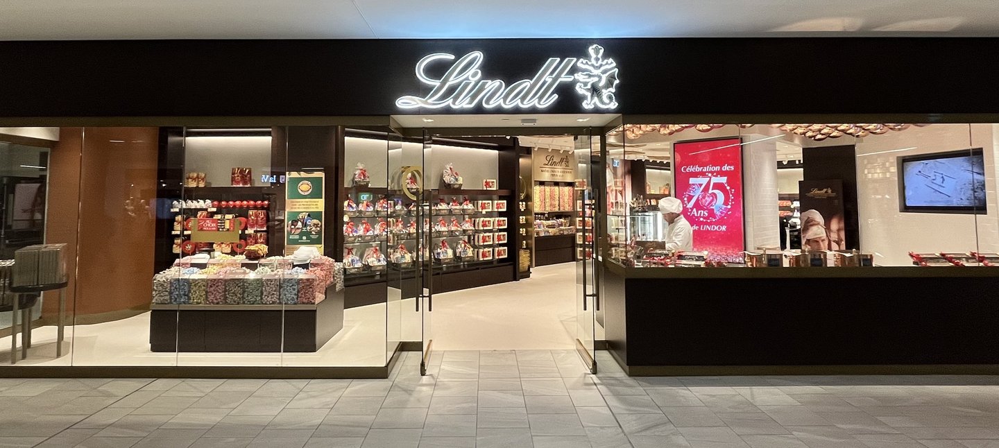 A wide view of the redesigned Lindt flagship storefront, with glass walls showing the shelves and displays inside