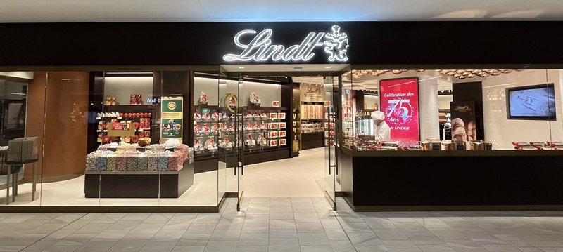 A wide view of the redesigned Lindt flagship storefront, with glass walls showing the shelves and displays inside