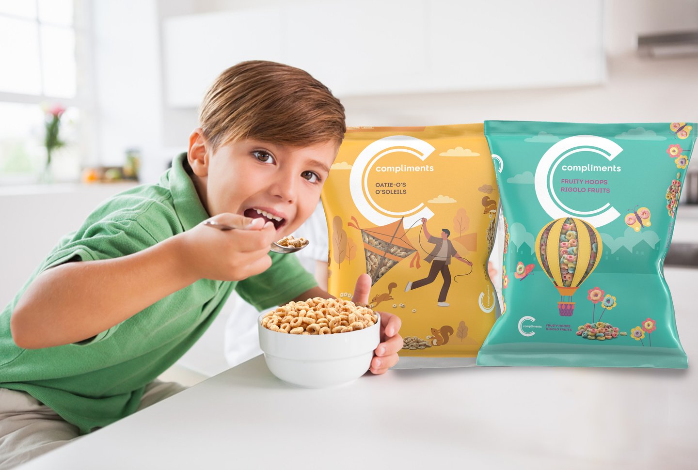 A boy eating cereal from a bowl beside Compliments Oatie-O's and Fruity Hoops cereal bags in a kitchen