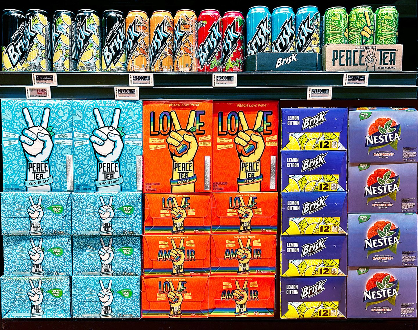 A store display of Peace Tea Peach Love Pride cases between Brisk and Nestea stacks
