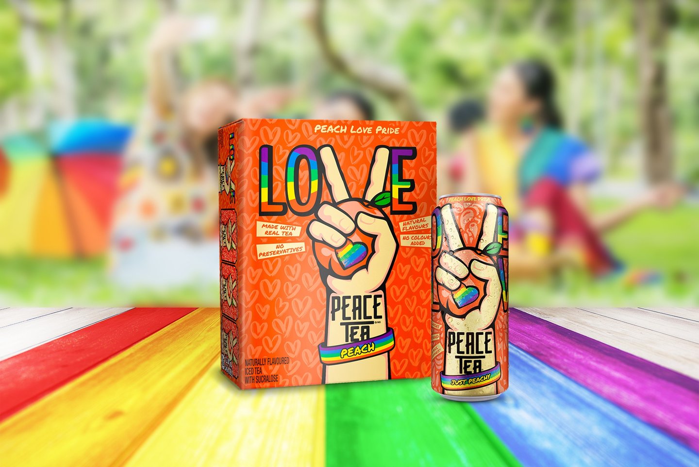 The Peace Tea Peach Love Pride 12-pack and can on rainbow boards at a park picnic