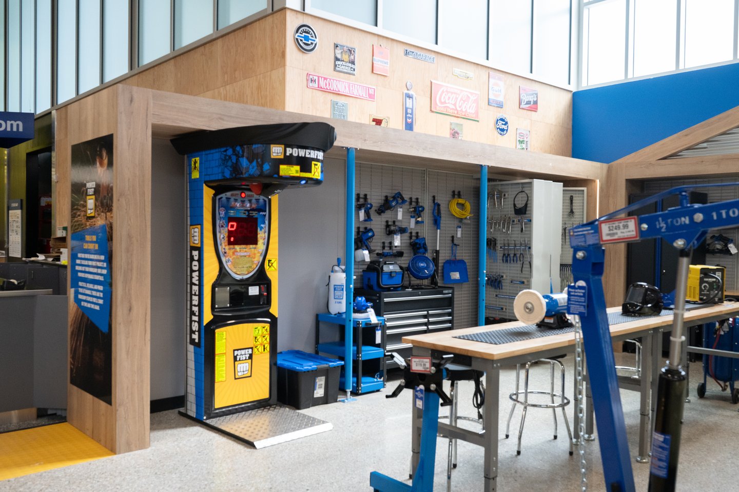 A Powerfist punching bag arcade game inside the garage display, beside tool workbenches