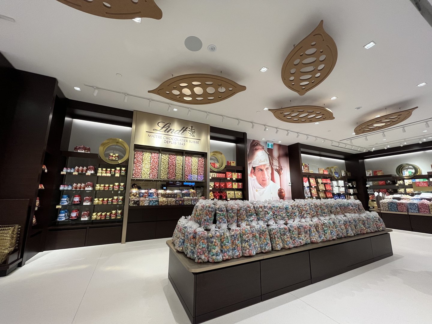 Gold cocoa pod shapes forming a canopy over the Lindt store's Pick & Mix island