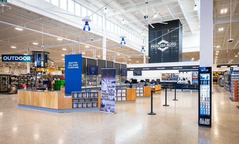 Inside the Princess Auto flagship entrance: a welcome desk, 'Built for you, more to explore' signage and the outdoor department beyond