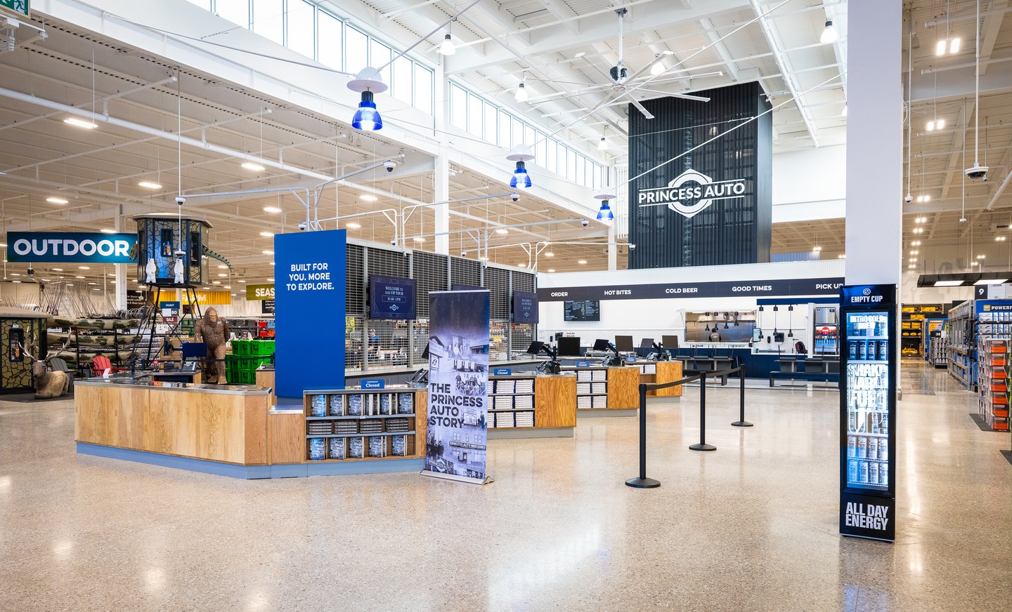 Inside the Princess Auto flagship entrance: a welcome desk, 'Built for you, more to explore' signage and the outdoor department beyond