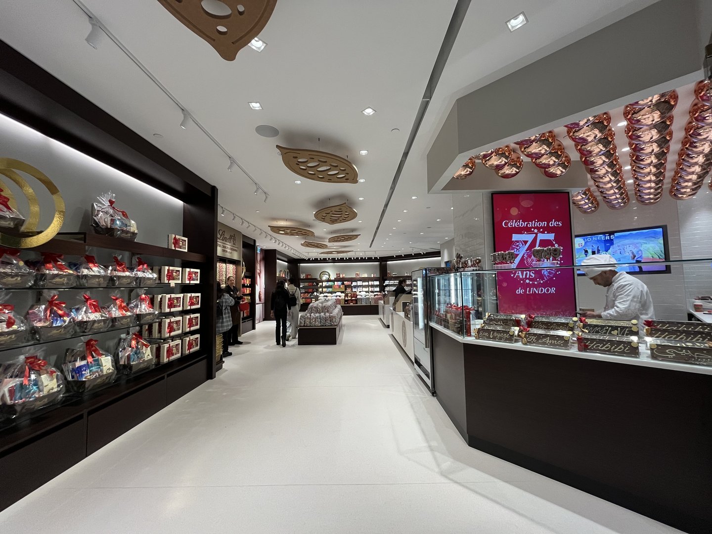 The redesigned Lindt store entrance with the maitre chocolatier working at a counter by the storefront