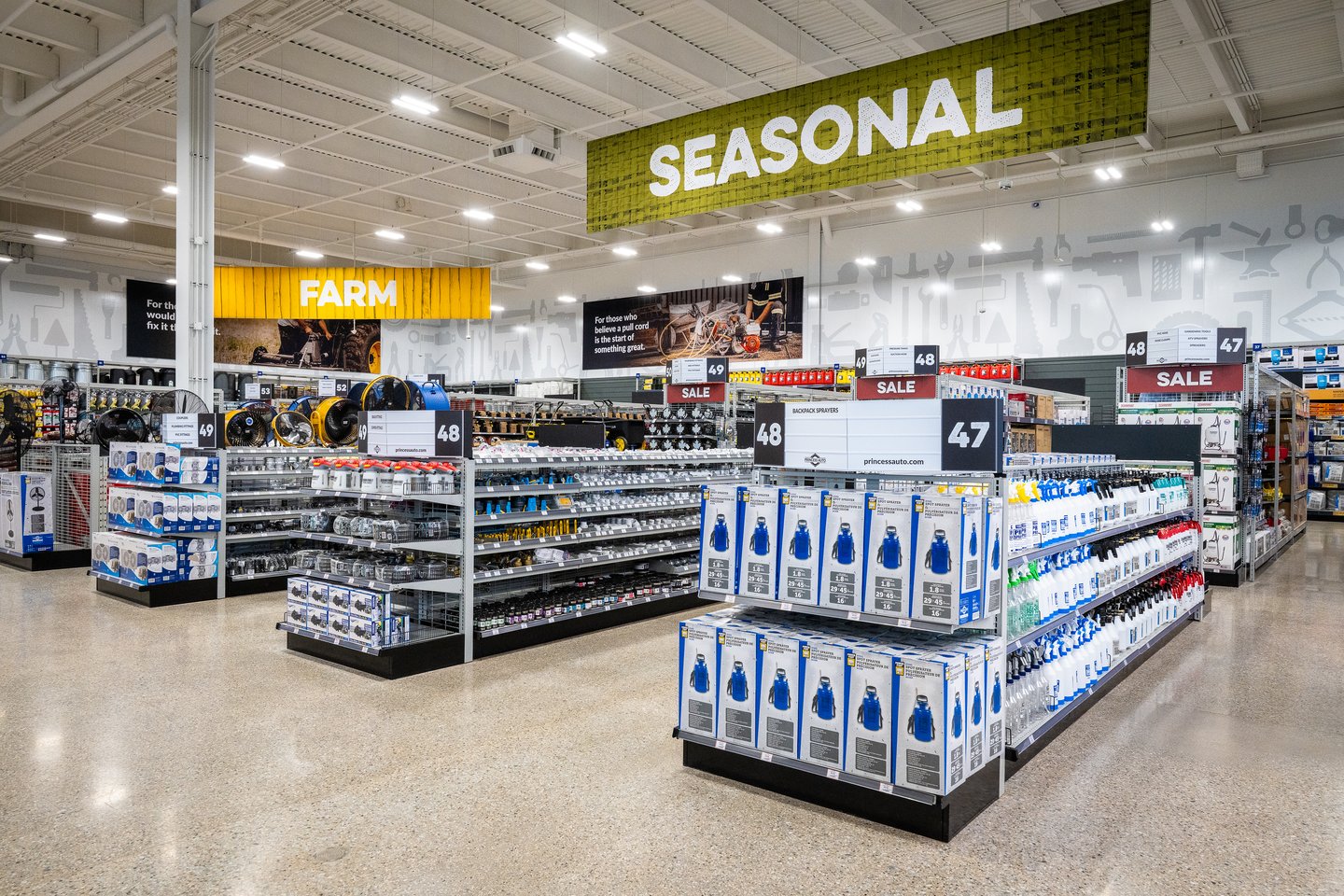 The Seasonal department at Princess Auto, with the Farm department sign beyond and water jug displays in the aisle
