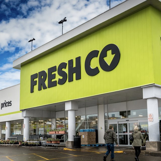 The FreshCo storefront with its lime green fascia and black logo with a downward arrow