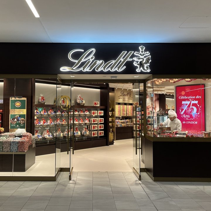 The Lindt flagship storefront at the Montreal Eaton Centre, with the illuminated Lindt sign over glass doors and shelves of chocolate inside